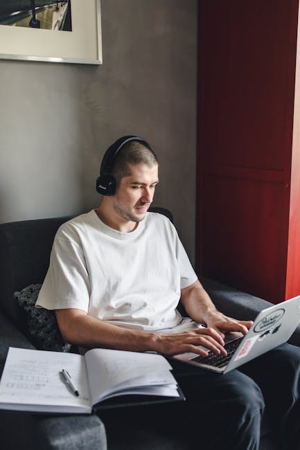 Developer writing code on a laptop in a dimly lit workspace